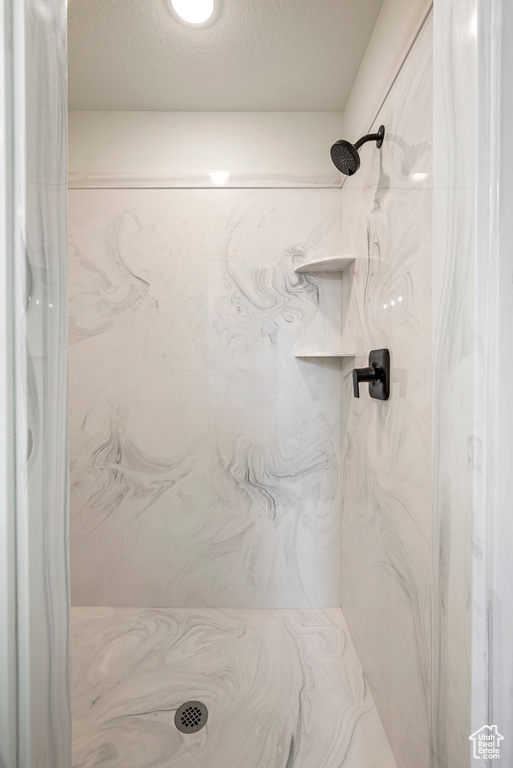 Bathroom with a textured ceiling and a shower with shower curtain