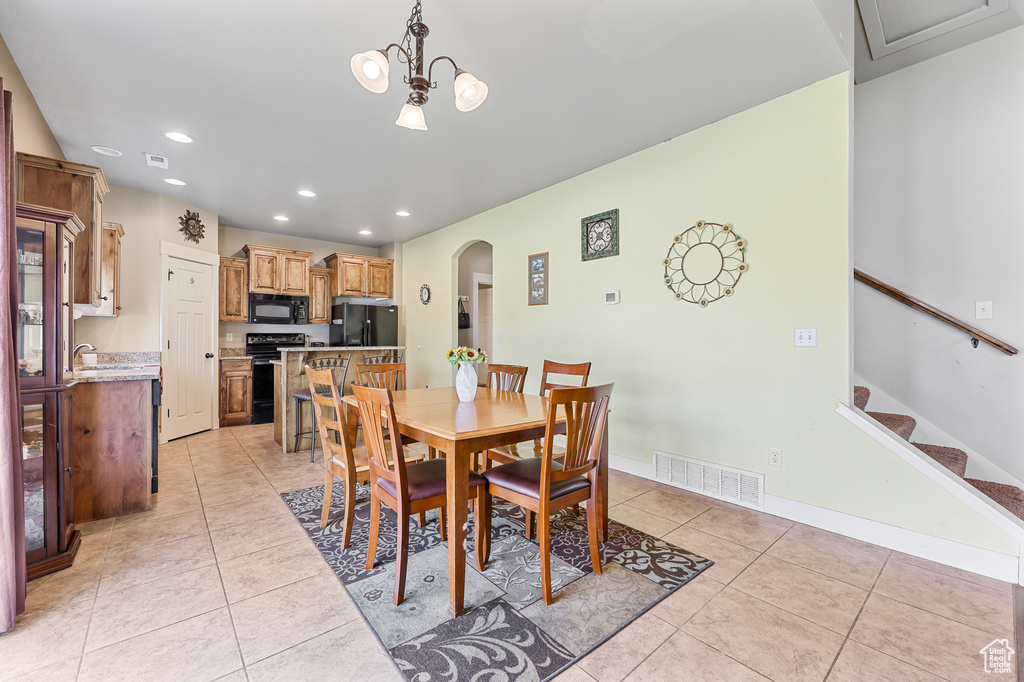 Dining room featuring sink, an inviting chandelier, and light tile patterned floors