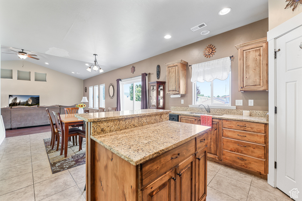 Kitchen featuring light stone counters, ceiling fan, lofted ceiling, and light tile patterned floors