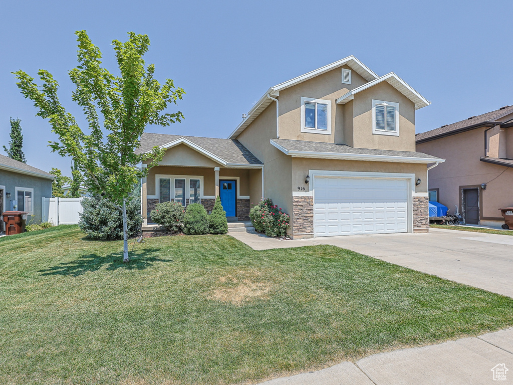 Craftsman house featuring a garage and a front lawn