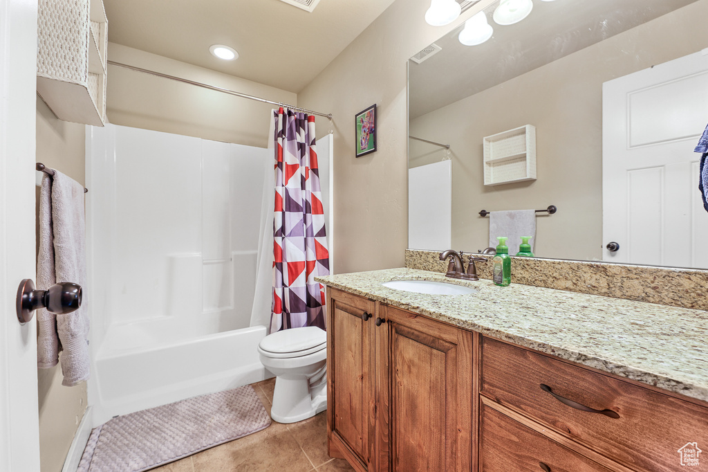 Full bathroom with shower / tub combo with curtain, vanity, tile patterned floors, and toilet