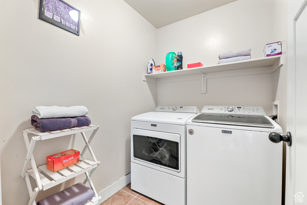 Washroom featuring washer and dryer and light tile patterned floors