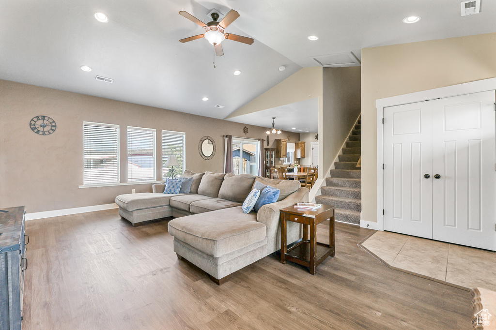 Living room with wood-type flooring, high vaulted ceiling, and ceiling fan