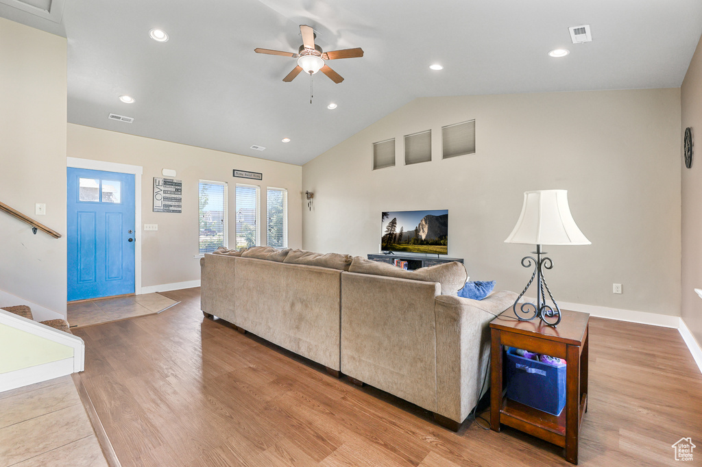 Living room featuring vaulted ceiling, light wood-type flooring, and ceiling fan