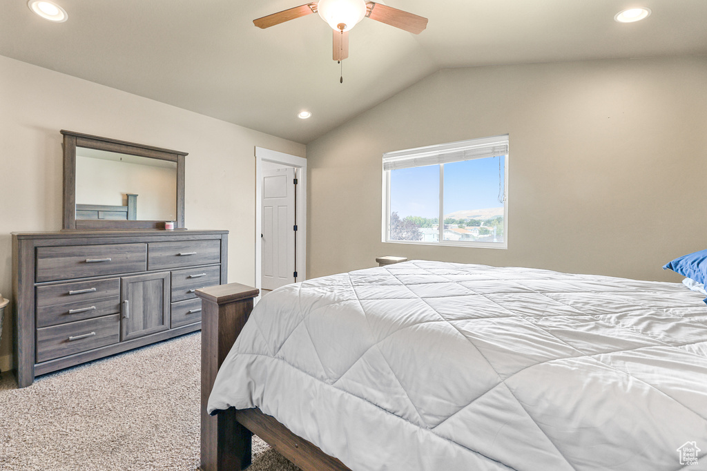 Bedroom featuring ceiling fan, lofted ceiling, and light colored carpet