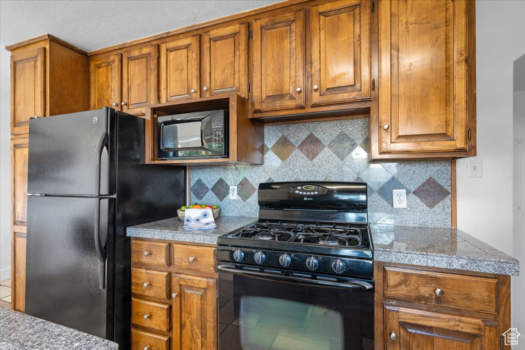 Kitchen featuring black appliances and decorative backsplash