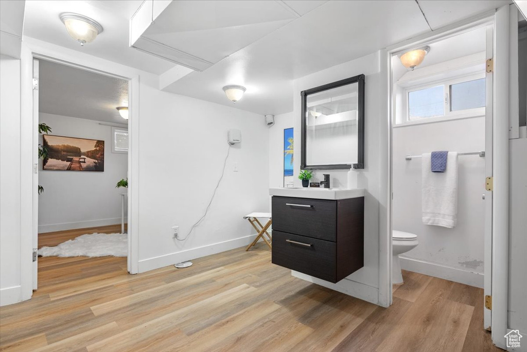 Bathroom featuring hardwood / wood-style floors, vanity, and toilet