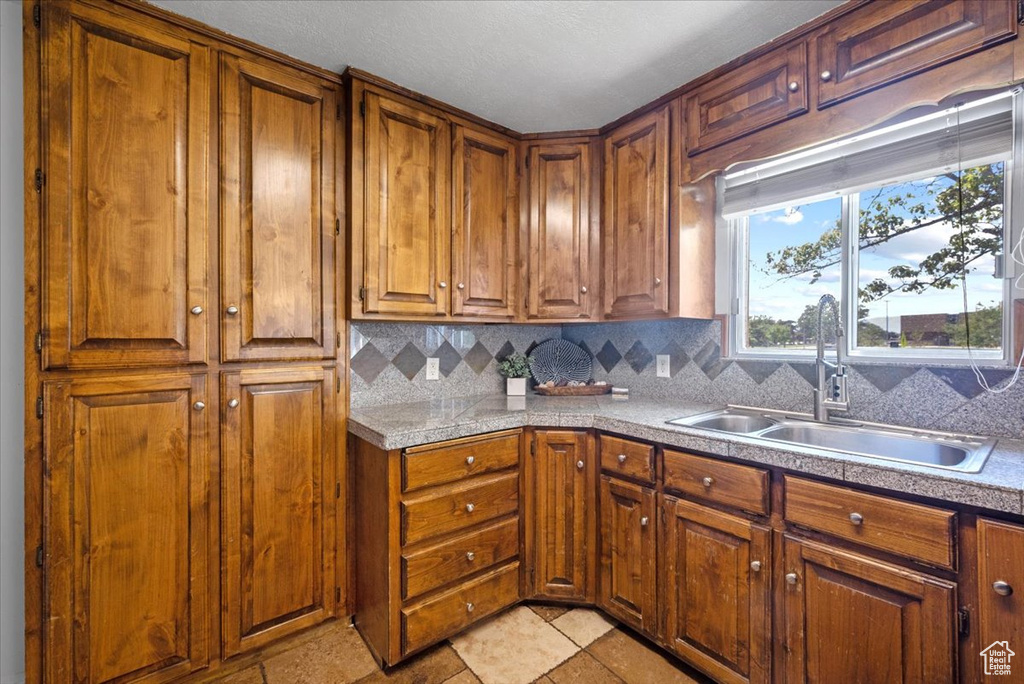 Kitchen featuring sink, tasteful backsplash, and light tile patterned floors