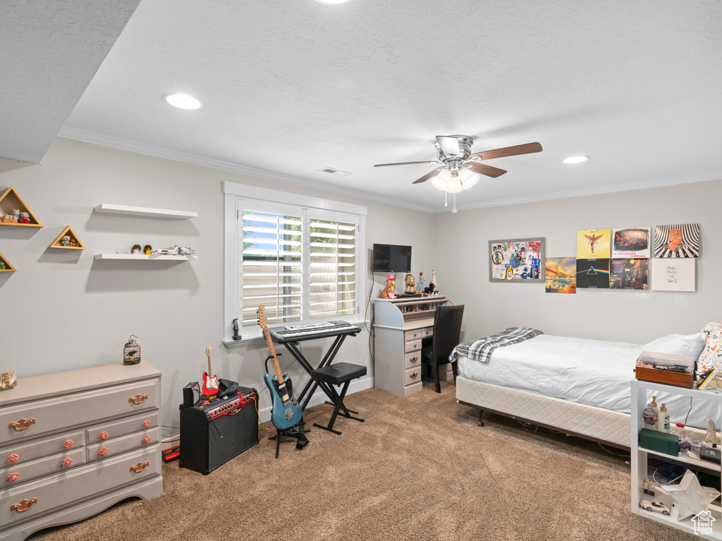 Bedroom featuring ornamental molding, carpet flooring, a textured ceiling, and ceiling fan