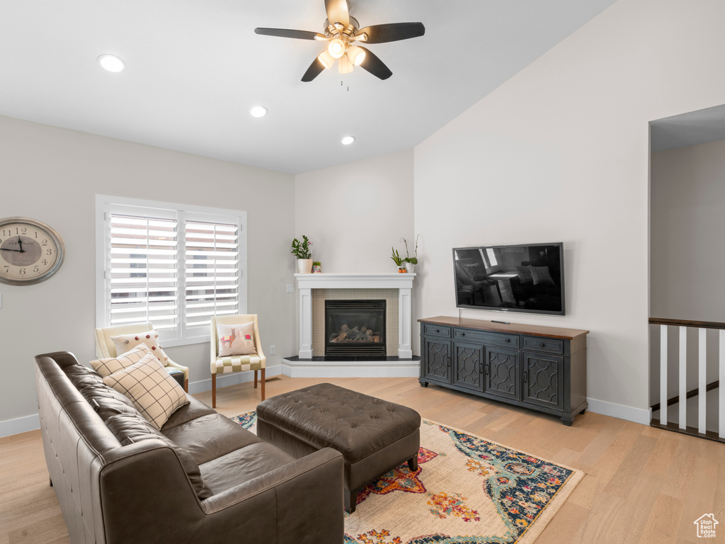 Living room with lofted ceiling, light hardwood / wood-style floors, and ceiling fan