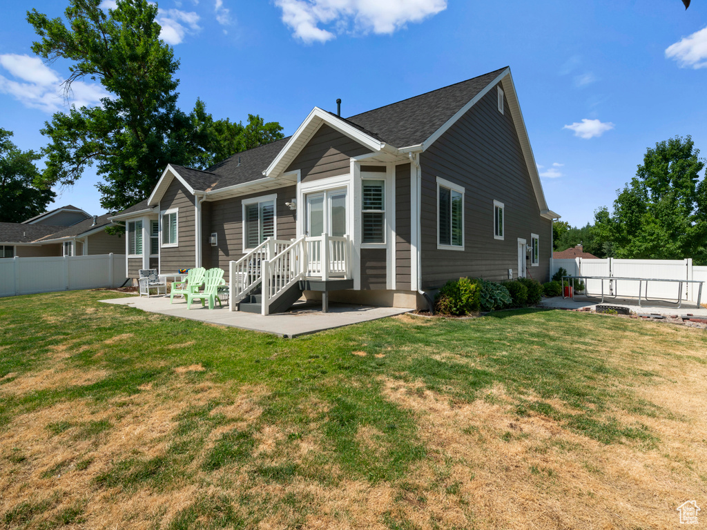 Back of property with a patio and a lawn