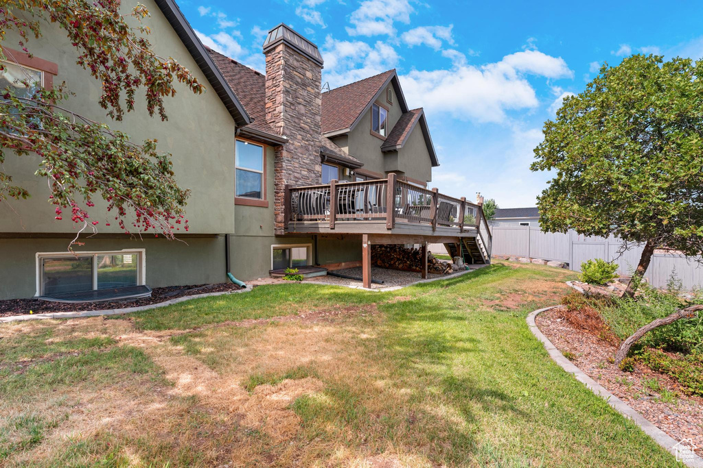 Back of house featuring a deck and a lawn