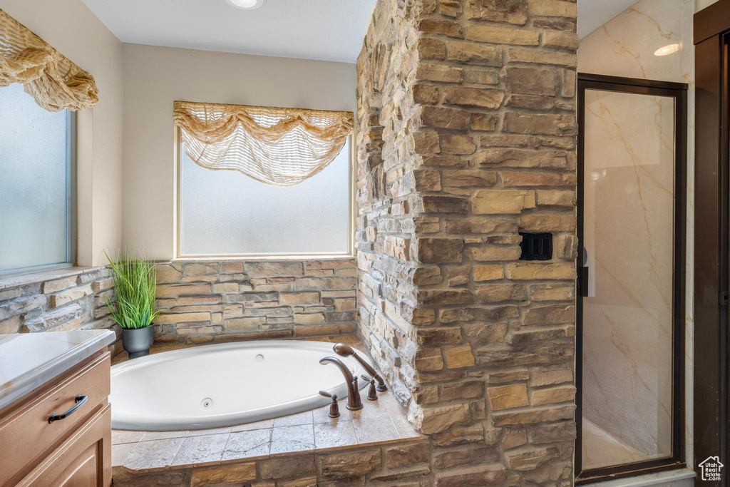 Bathroom with vanity, separate shower and tub, and a healthy amount of sunlight