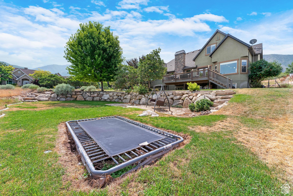 View of yard with a deck with mountain view