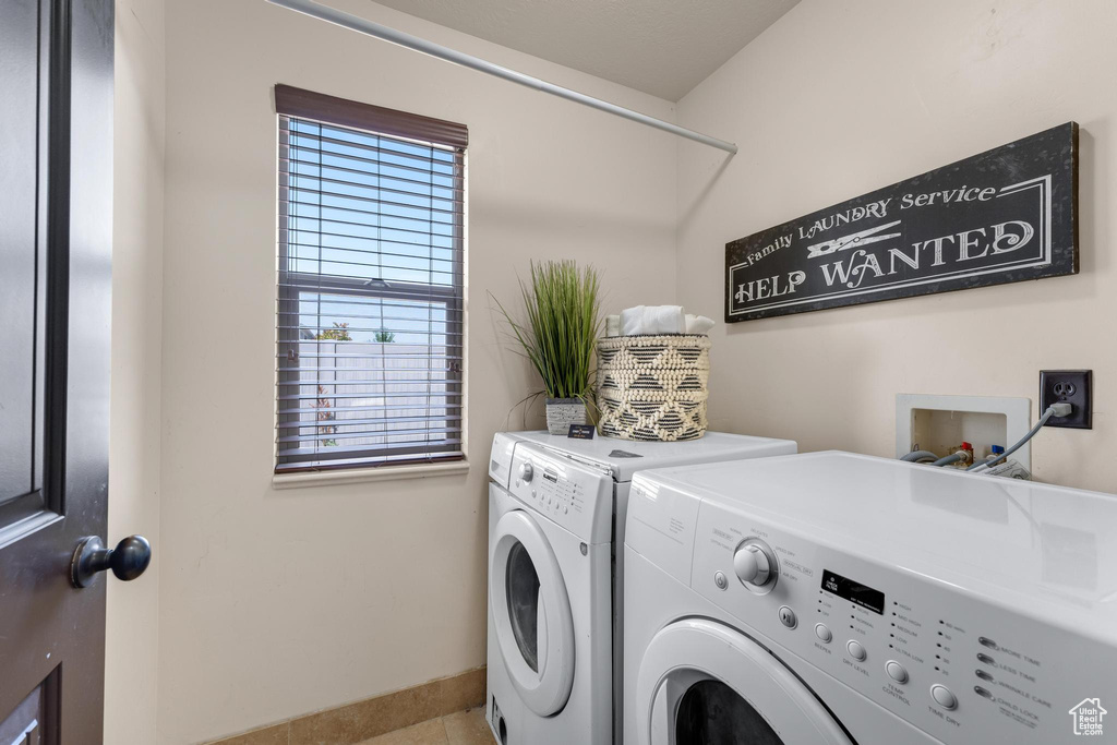 Laundry area featuring washer and clothes dryer and light tile patterned floors