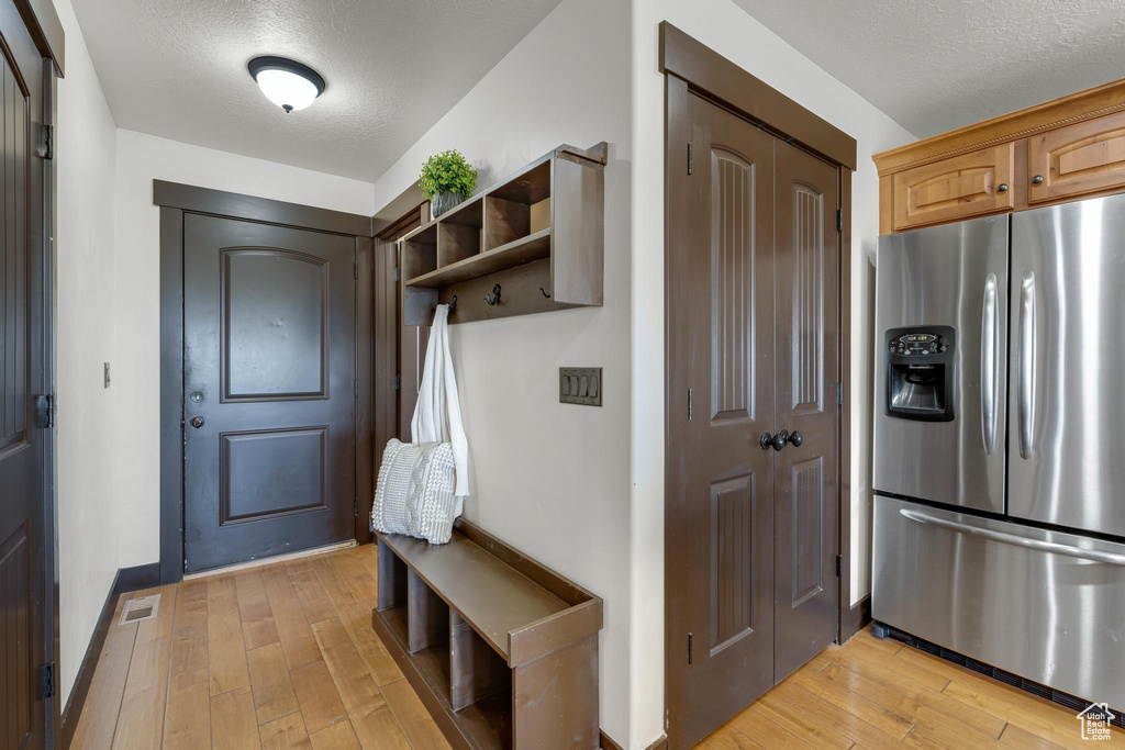 Mudroom with light hardwood / wood-style flooring and a textured ceiling