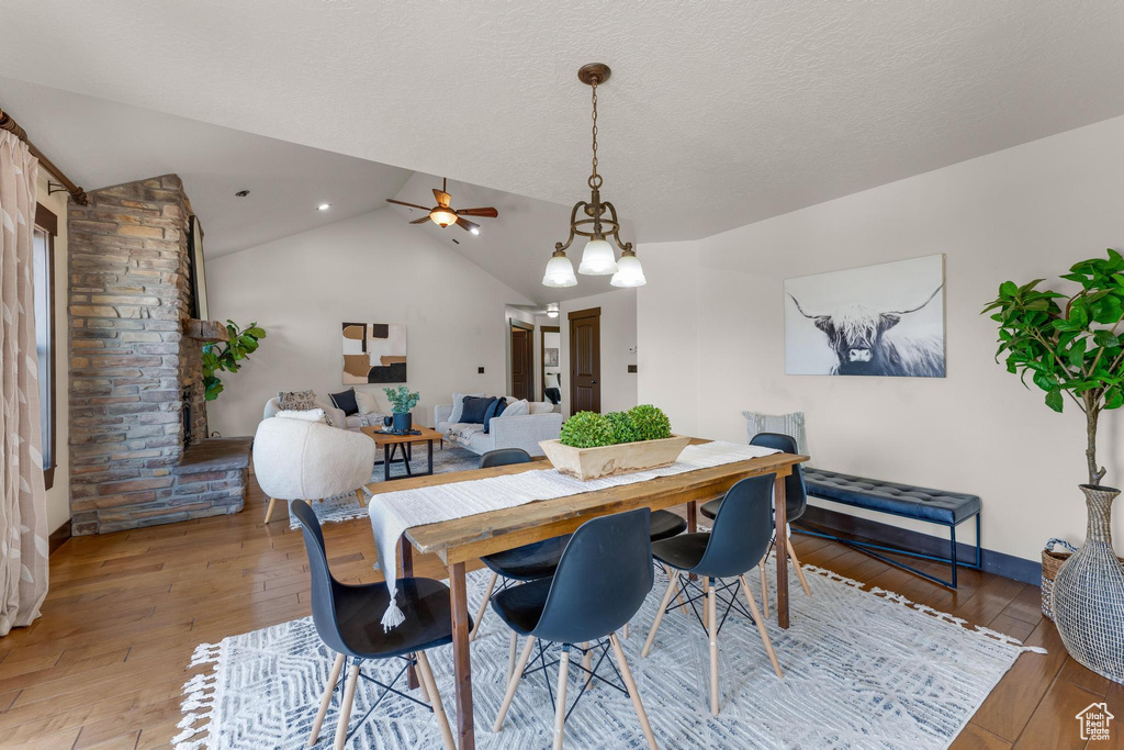 Dining room featuring a textured ceiling, ceiling fan, lofted ceiling, and hardwood / wood-style floors