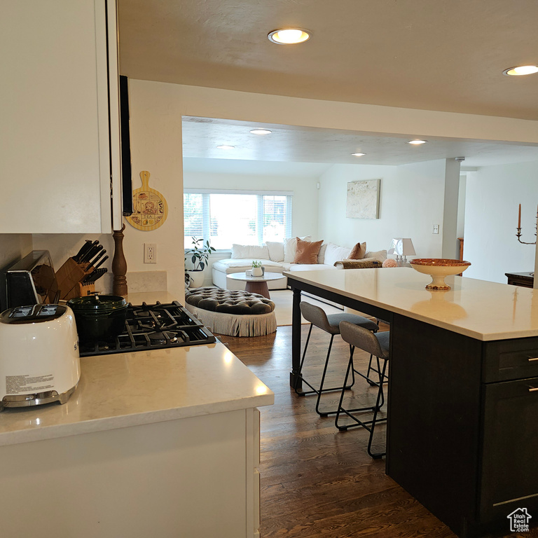 Kitchen with a kitchen bar, a kitchen island, and dark wood-type flooring