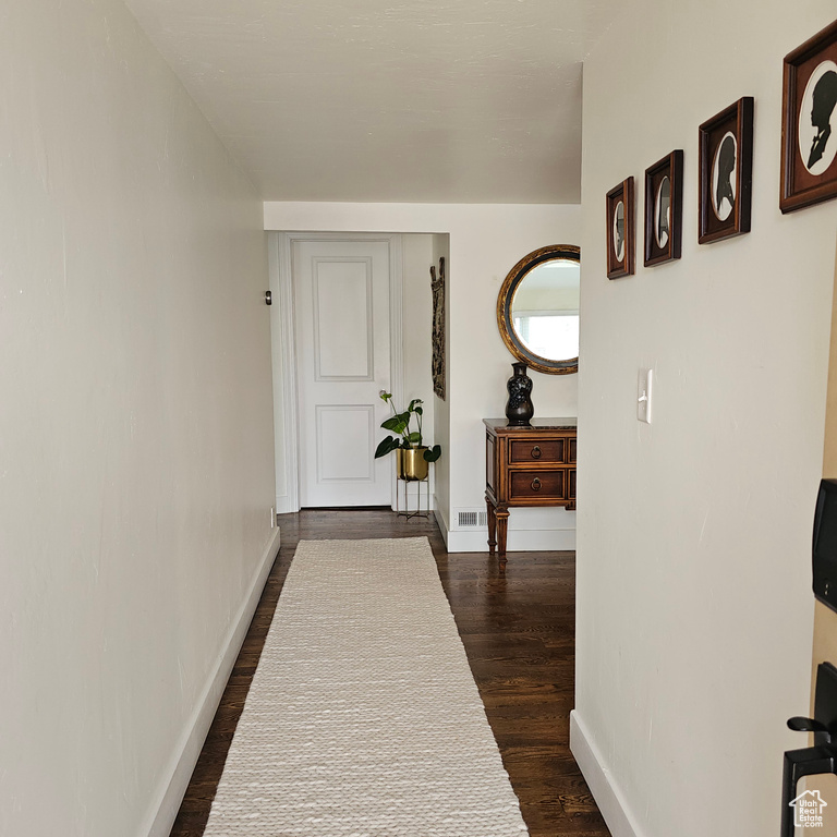 Hallway featuring dark wood-type flooring