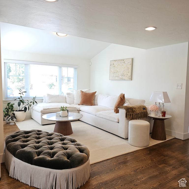 Living room with lofted ceiling and hardwood / wood-style floors