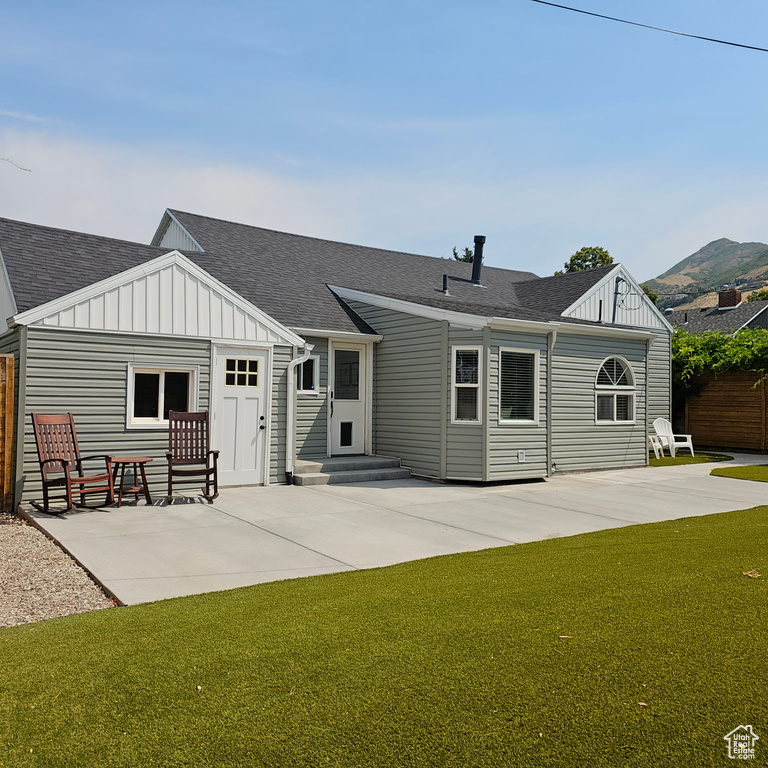 Rear view of house with a patio area and a lawn