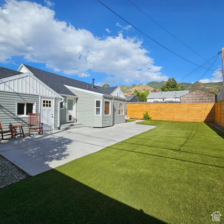 Rear view of house featuring a yard and a patio