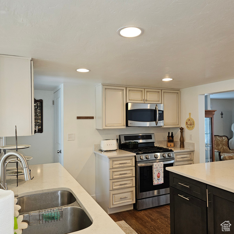 Kitchen featuring sink, cream cabinets, dark hardwood / wood-style floors, and stainless steel appliances