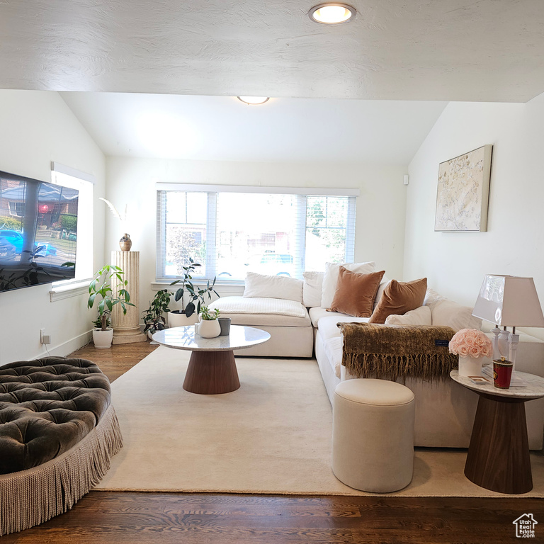 Living room with hardwood / wood-style flooring and vaulted ceiling