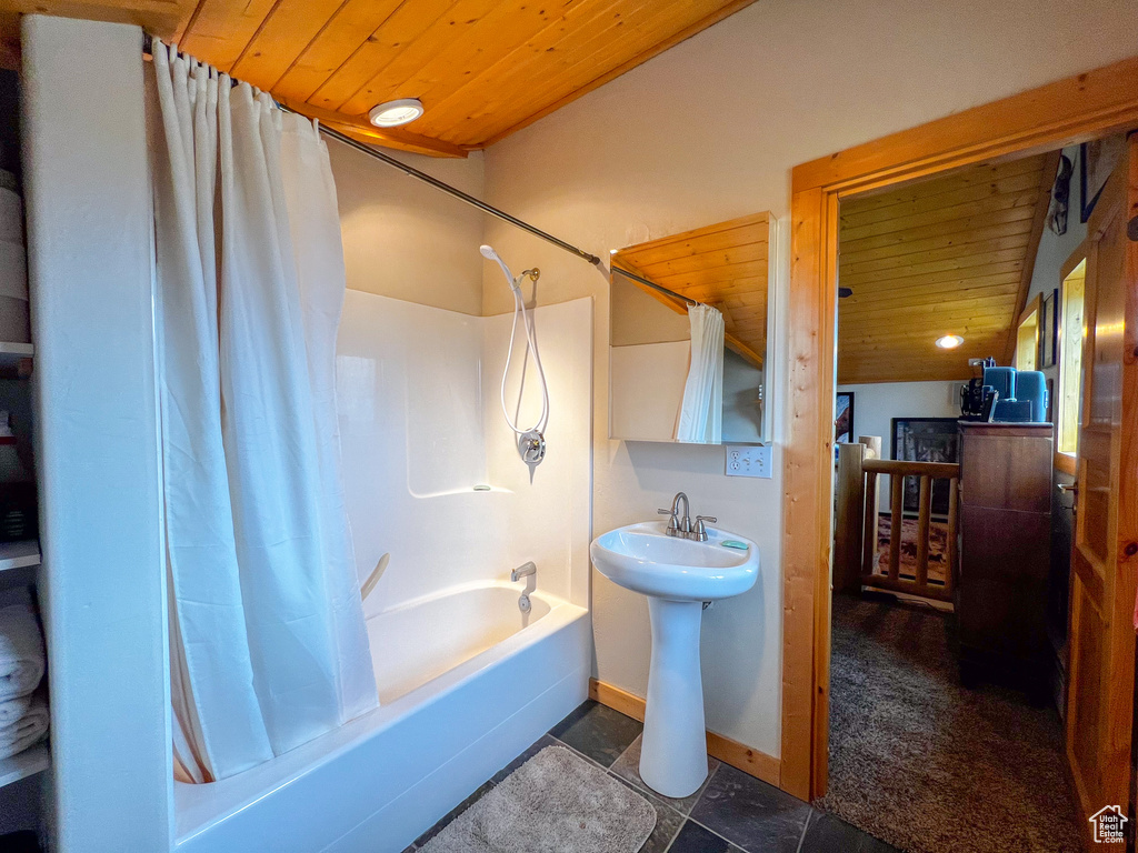 Bathroom with tile patterned floors, wooden ceiling, and shower / tub combo with curtain