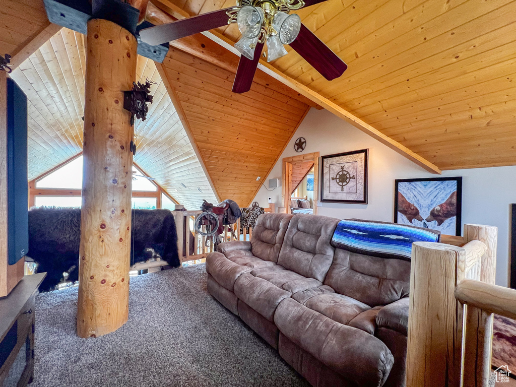 Carpeted living room featuring ceiling fan, lofted ceiling with beams, and wooden ceiling