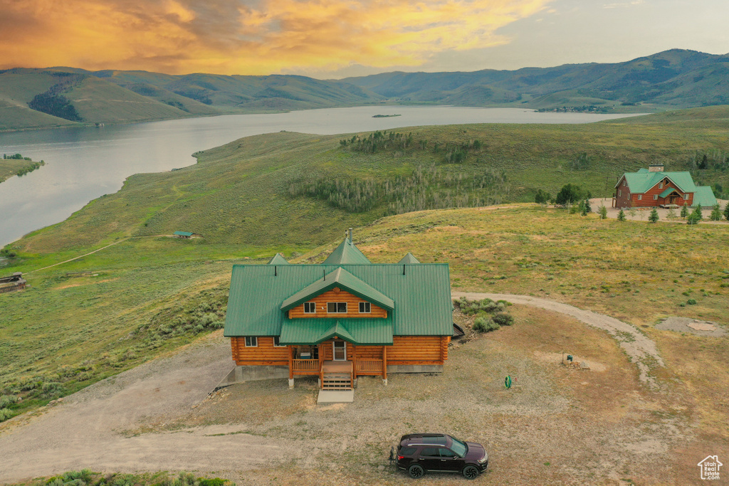 Aerial view at dusk featuring a water and mountain view and a rural view