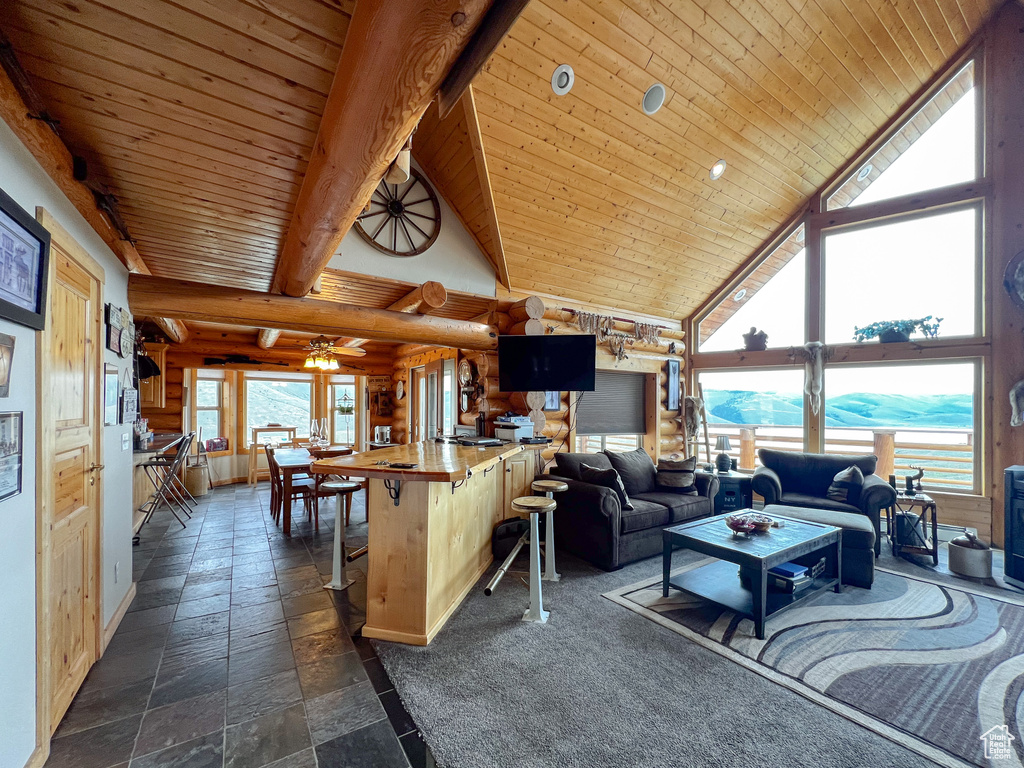 Tiled living room featuring beamed ceiling, ceiling fan, and high vaulted ceiling