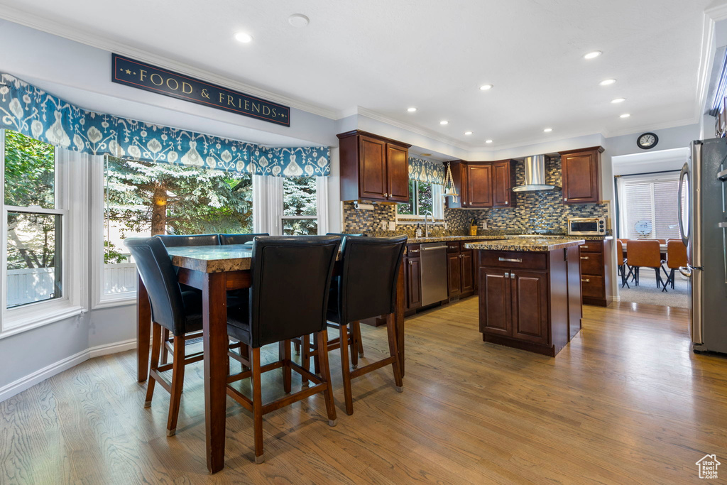 Dining area featuring light hardwood / wood-style floors, crown molding, and sink