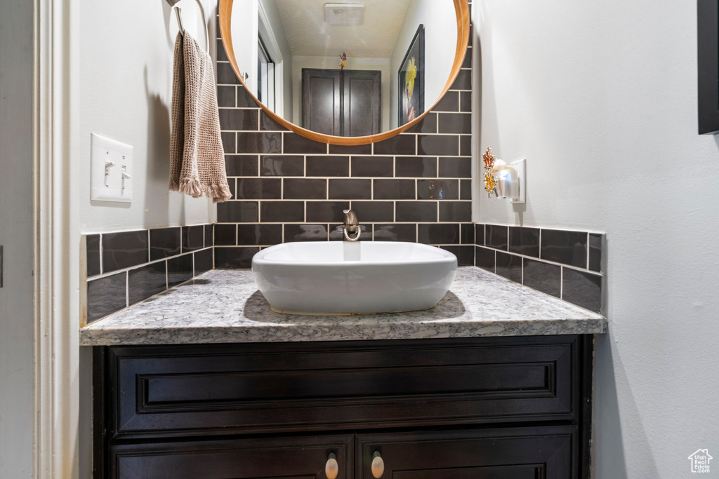 Bathroom featuring vanity and tasteful backsplash