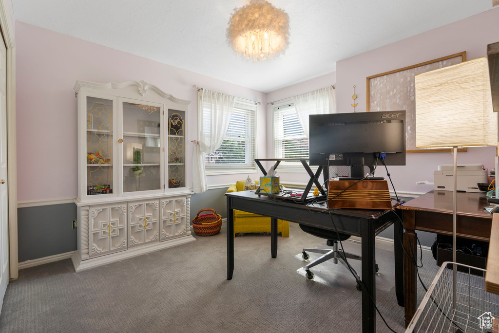 Office area featuring an inviting chandelier and carpet floors