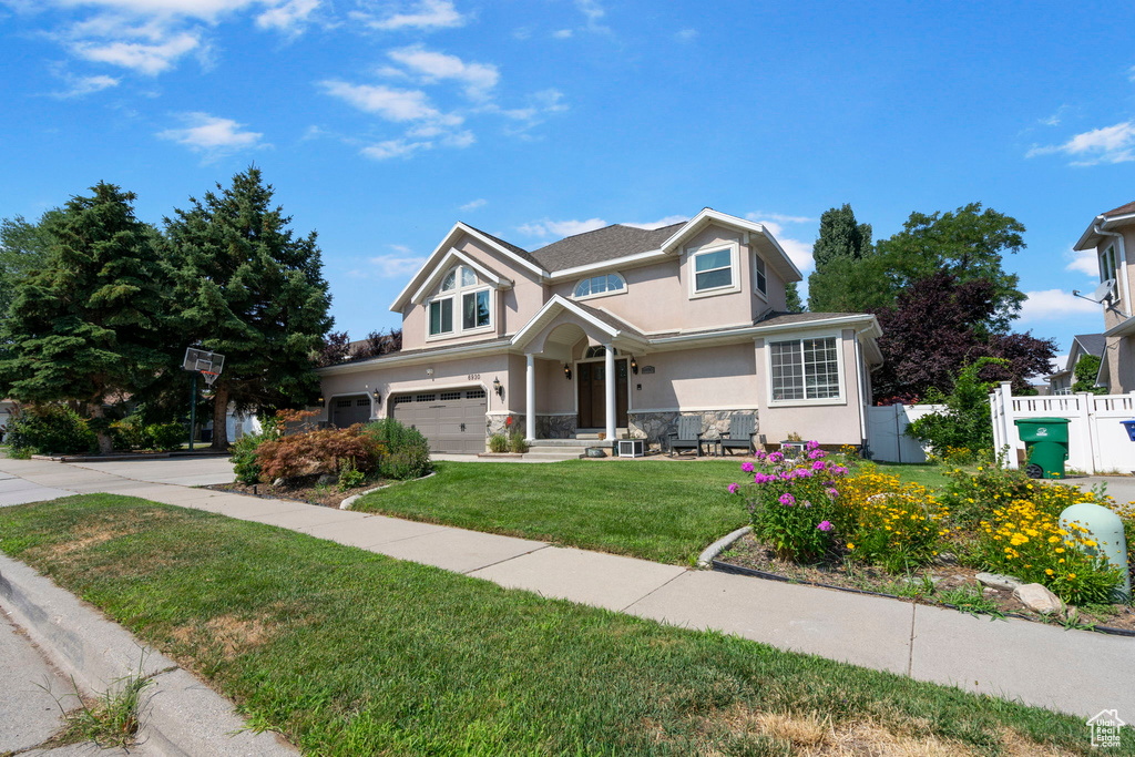 View of front facade with a garage and a front lawn