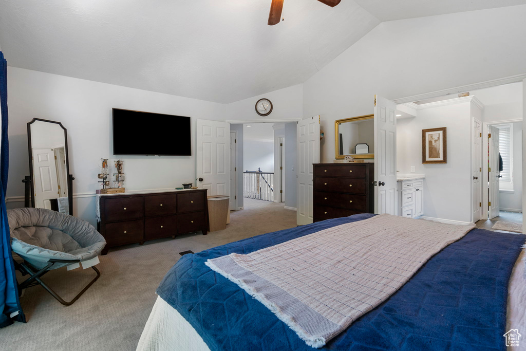 Carpeted bedroom with ensuite bathroom, ceiling fan, and vaulted ceiling