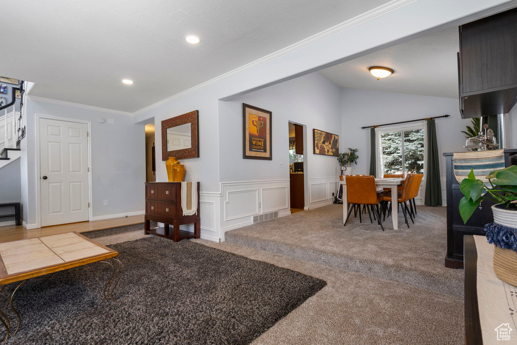 Interior space featuring lofted ceiling and crown molding