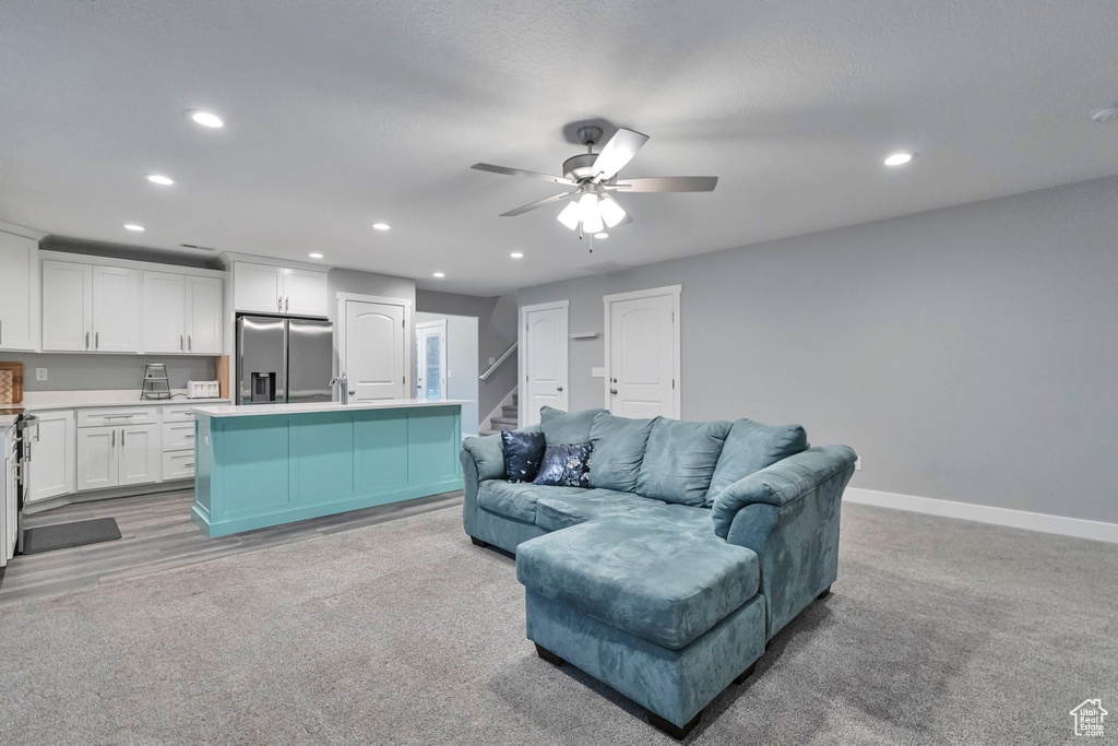 Living room with sink, ceiling fan, and light hardwood / wood-style floors