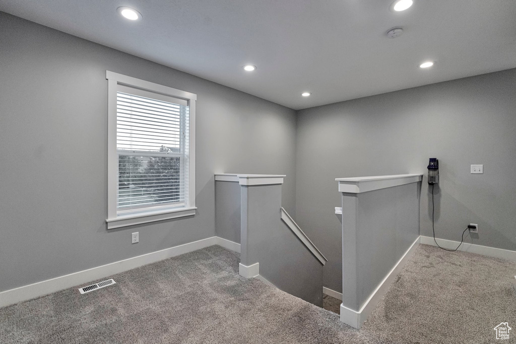 Staircase featuring light carpet