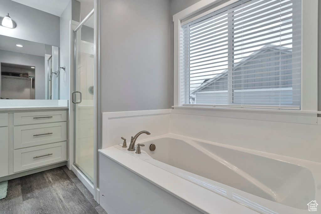 Bathroom with a healthy amount of sunlight, plus walk in shower, and hardwood / wood-style floors