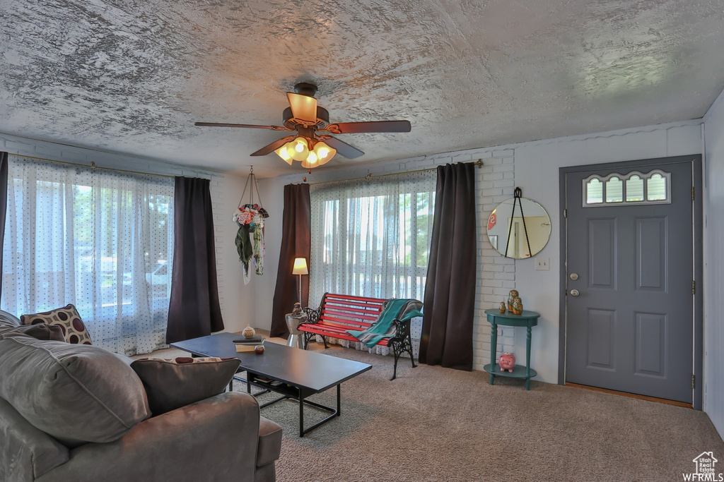 Carpeted living room with ceiling fan