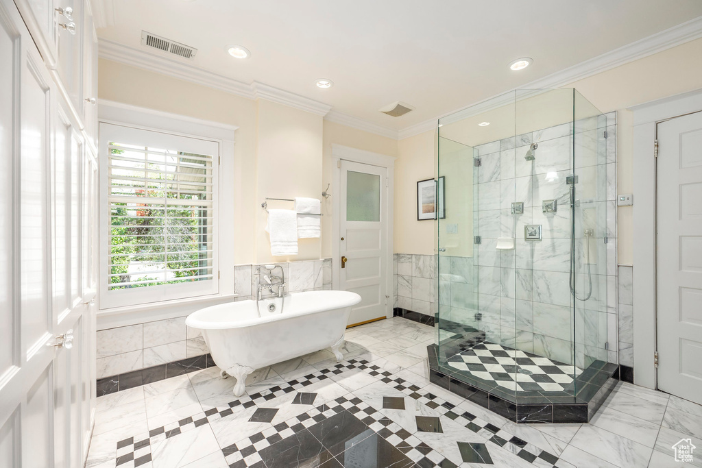 Bathroom featuring tile walls, independent shower and bath, tile patterned floors, and crown molding