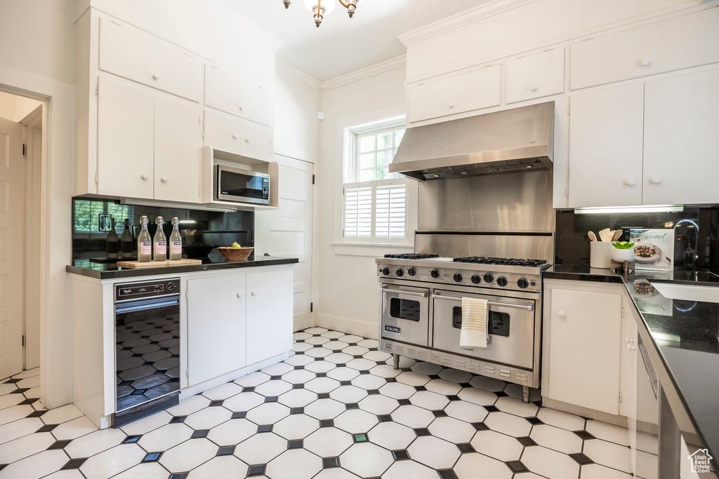 Kitchen with light tile patterned flooring, appliances with stainless steel finishes, tasteful backsplash, and white cabinets