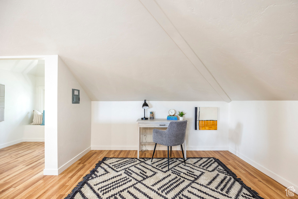 Office with lofted ceiling and light hardwood / wood-style floors