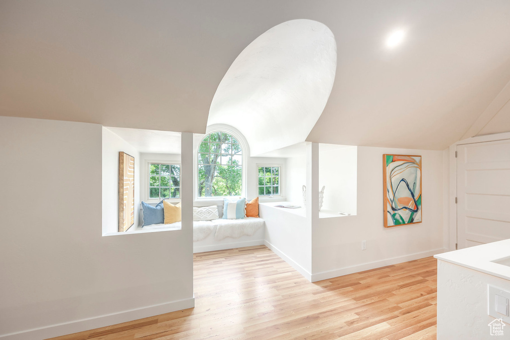 Corridor with lofted ceiling and light hardwood / wood-style flooring