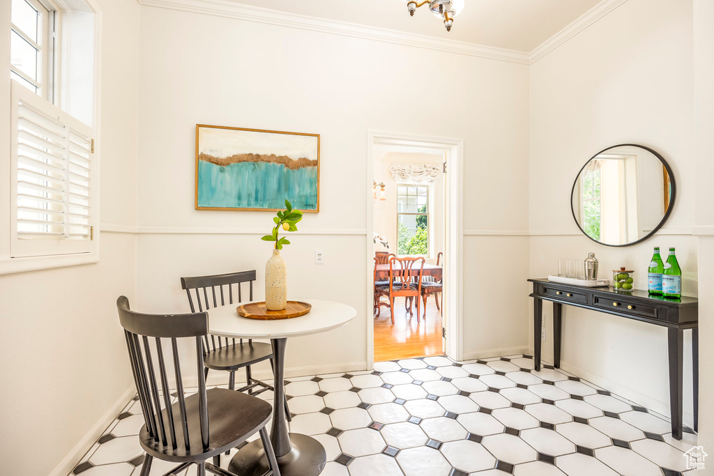 Dining area featuring a wealth of natural light, ornamental molding, and light tile patterned floors