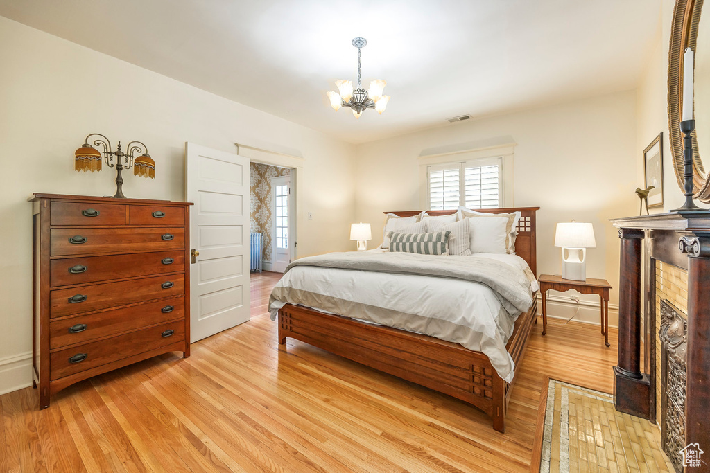 Bedroom with an inviting chandelier and light wood-type flooring