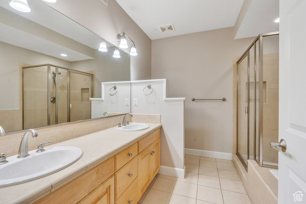 Bathroom featuring tile patterned flooring, an enclosed shower, and double vanity