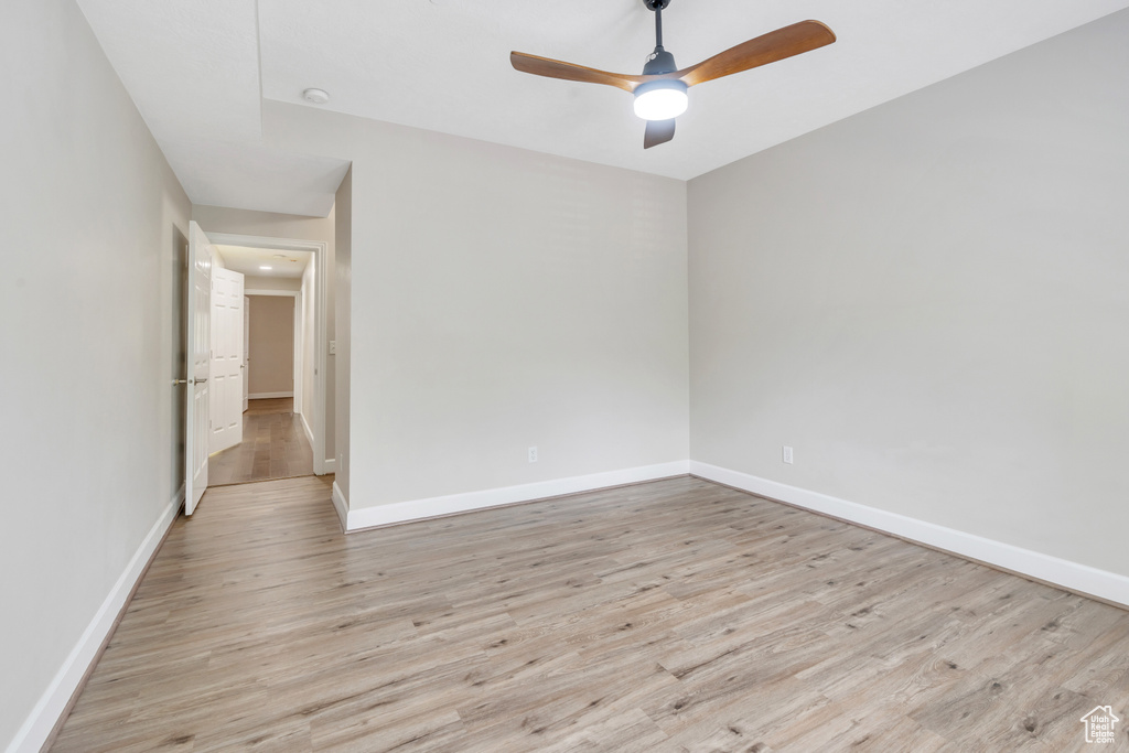 Empty room with light wood-type flooring and ceiling fan